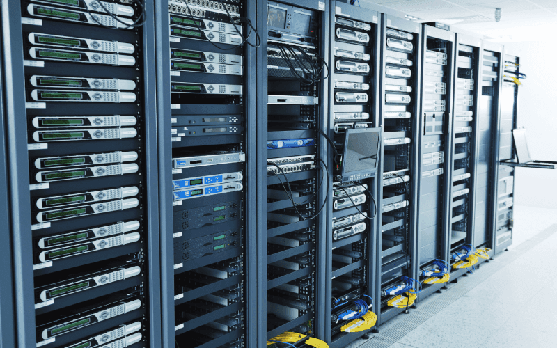 A row of server racks filled with computer equipment and cables in a data center. The room is well-lit and orderly, conveying a high-tech atmosphere. A row of server racks filled with computer equipment and cables in a data center. The room is well-lit and orderly, conveying a high-tech atmosphere.